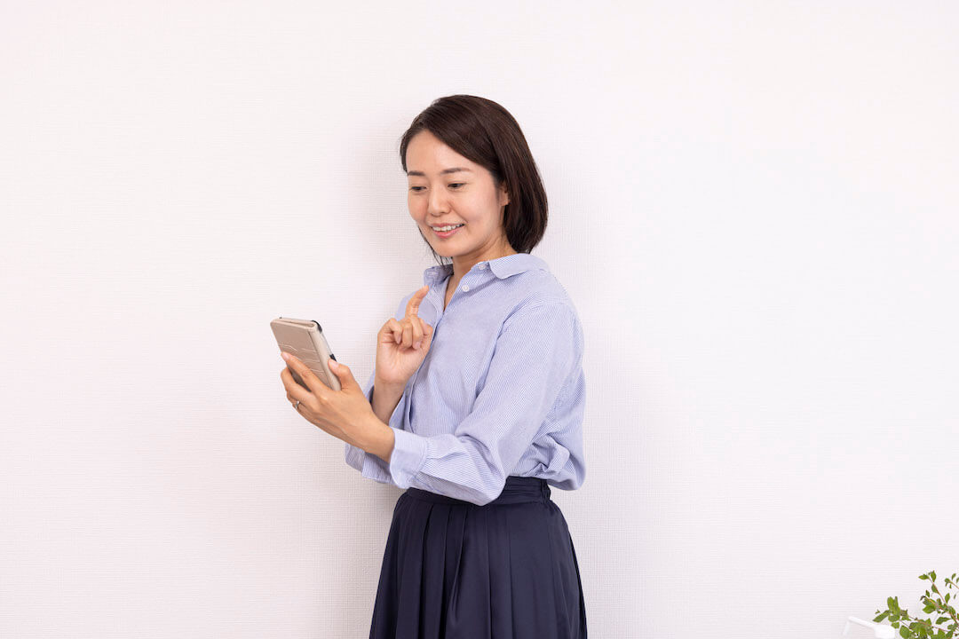 スマホで施術のお問い合わせをする女性